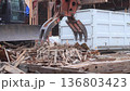 建物の解体現場で木材を掴む重機 136803423