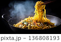 Delicious steaming noodles being lifted with chopsticks from a wok. 136808193