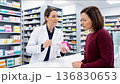 Female pharmacist consulting a woman about a medication in a drugstore, close up. 136830653