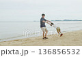 Happy family man and child kid enjoy beach summer travel vacation trip together, swinging by calm sea, creating joyous memories on wide sandy shore with gentle ocean waves. 136856532