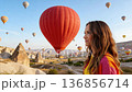 Girl traveler vacations beautiful destination in Goreme, Turkey. Fabulous Cappadocia with flying air balloons at sunrise, Anatolia 136856714