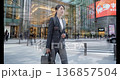 Businesswoman walking through Tokyo's business district 136857504