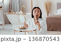 Daily makeup. Young pretty asian woman making make-up herself, applying rouge on face, looking at mirror at bathroom interior, slow motion Daily makeup. Young pretty asian woman making make-up herself, applying rouge on face, looking at mirror at bathroom interior, slow motion 136870543
