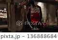 Close-up of a waiter pouring alcoholic and non-alcoholic drinks at a wedding reception. Elegant serving moment with glasses being filled at the bar, festive atmosphere, and professional hospitality 136888684