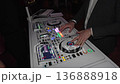 Close-up of a DJ playing music at a party, detailed shot of hands mixing tracks on a professional DJ controller. Energetic nightlife atmosphere with live performance, sound mixing, and entertainment 136888918
