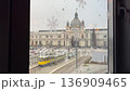Lviv train station view through window with snowflakes, tram passing by, winter city scene Ukraine urban transport snowy day video. 136909465