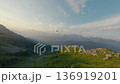 Black helicopter landing to pick up people mountain summit aerial view 136919201