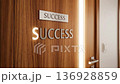 Office door sign revealing a glowing success word 136928859
