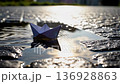 Paper boat sailing in a street puddle 136928863