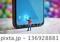 Miniature man holding glowing smartphone screen 136928881