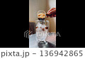 Woman barista making iced coffee by pouring espresso into glass with iced. 136942865