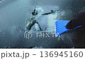 An unidentified hand cleans the car window from ice.  136945160