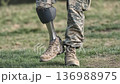 Military personnel walks confidently on grass with a prosthetic leg during a sunny afternoon outside 136988975
