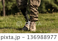 Military personnel walks confidently on grass with a prosthetic leg during a sunny afternoon outside 136988977