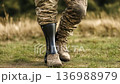 Military personnel walks confidently on grass with a prosthetic leg during a sunny afternoon outside 136988979