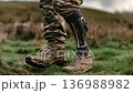 Military personnel walks confidently on grass with a prosthetic leg during a sunny afternoon outside 136988982