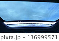 Enjoying a serene drive with an expansive view of the sky through the sunroof on a calm day. Opening the car's panoramic sunroof. 136999571