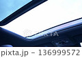 Closing the car's panoramic sunroof. Enjoying a serene view through the sunroof while driving under a bright, clear sky on a sunny day 136999572