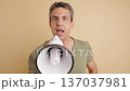 Angry man shouting into megaphone announcing news 137037981