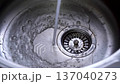A stream of water flows into a metal sink 137040273