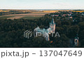 This clip showcases Stranov Castle located in a lush countryside area. View the remarkable architecture surrounded by nature and nearby farm fields during sunset hours. 137047649