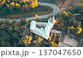 Stranov Castle is shown in detail from above. The camera captures the castle's structure, the surrounding trees, and the road nearby. This view highlights the beauty of the area. 137047650