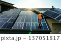 Installers Mount Sleek Solar Panels on Contemporary Roof at Sunrise 137051817