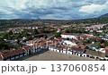 Villa de Leyva seen from central park, Drone aerial view of colonial town, Scenic flight over white houses and red tile roofs 137060854