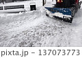 Snow removal from pathway during winter in a city park using a snowplow and clearing sidewalks 137073773