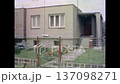 Modern townhouses exteriors in spring with fresh green lawns in front of country houses. Contemporary residential architecture in suburban street. Old film. Archival retro 1970s. Vintage archive 137098271