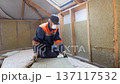 Insulation of a frame house with mineral wool. Cutting, fitting, laying insulation. Construction works. 137117532