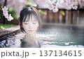 桜の咲く温泉露天風呂に入浴中の若い女性 137134615