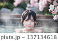 桜の咲く温泉露天風呂に入浴中の若い女性 137134618