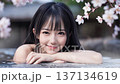 桜の咲く温泉露天風呂に入浴中の若い女性 137134619