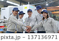 工場の中で円陣を組む作業員グループ 工場の中で円陣を組む作業員グループ 137136971