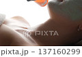 Professional esthetician applying hydrating spray on a client's d colletage during a treatment 137160299