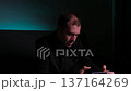 Frustrated and emotional man playing a video game on his mobile phone in a dark room 137164269