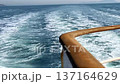 Dynamic White Wake and Foam Behind a Sailing Ship on the Blue Sea 137164629