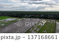 Aerial view of green paddy fields and coastal forest with village under cloudy sky. 137168661