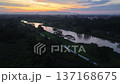 Aerial view drone footage over Labuh Banting river and adjacent road at sunset with town and distant hills 137168675