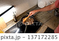 High angle view of a person stirring diced meat and onions with a wooden spatula in a frying pan 137172285