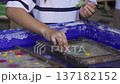 Close up of children hands holding paintbrushes in a plastic cup with colorful watercolor, creative art activity for kids. 137182152