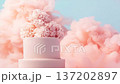 A cake with white layers and pink frosting stands against a soft pink cloud background. This display highlights dessert decoration for parties and gatherings with sweet treats 137202897