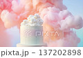 A cake is placed in a cloud of colorful smoke during an event. The unique design features swirls and decorations. The scene captures a creative moment in baking 137202898