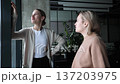 Two women are standing next to each other, one of them is smiling 137203975