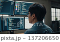 Asian software developer programming code on multiple monitors in modern tech office workspace 137206650
