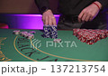Dealer Stacking Chips Meticulously Today. Dealer Organizing Red Chips With Focus And Precision 137213754