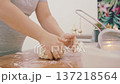 The hands of a female cook knead a lump of dough on a wooden table with white wheat flour. High quality 4k footage 137218564