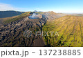 Cinematic aerial view of active Mount Bromo volcano emitting smoke with Mount Semeru in the distance at sunrise. Dramatic volcanic landscape in East Java, Indonesia. 137238885