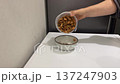 Dried shrimp, dried black soldier fly larvae in turtle food are poured into a ceramic bowl, rustling 137247903